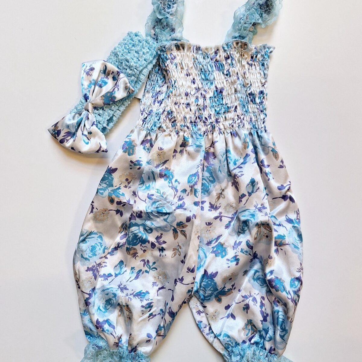 Dress your little one in style with this adorable floral romper made from comfortable 100% polyester. Complete with lace straps and a matching headband, it's the perfect outfit for any occasion!