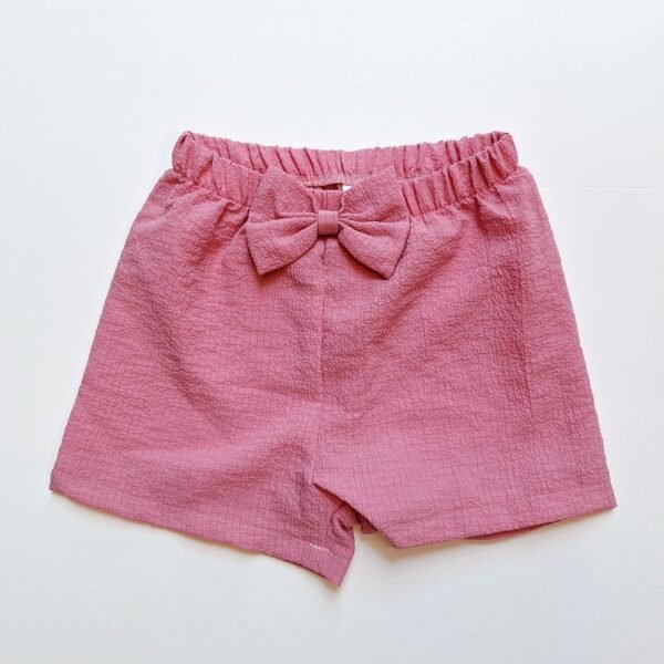 Baby girl's pink ribbed shorts adorned with a delightful bow tie, perfect for a stylish summer outfit.